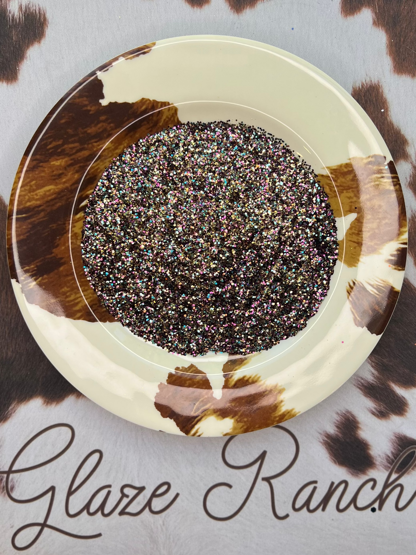 Decorative plate with a circular design on a cowhide surface with 'Glaze Ranch' branding.