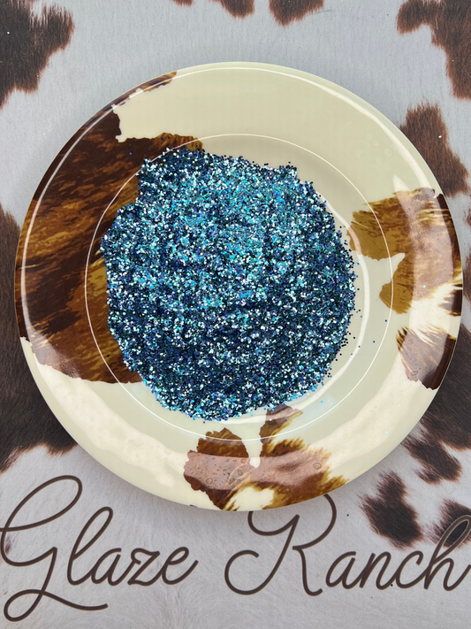 Blue glitter in a circular dish on a cow print background with 'Glaze Ranch' branding.