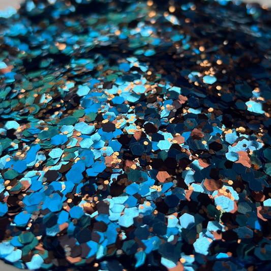 Blue glittery material in a bowl on a brown and white surface