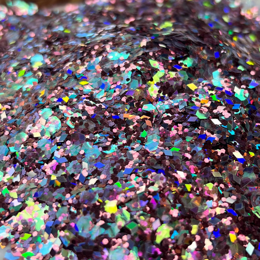 Multicolored glitter in a clear container on a patterned surface