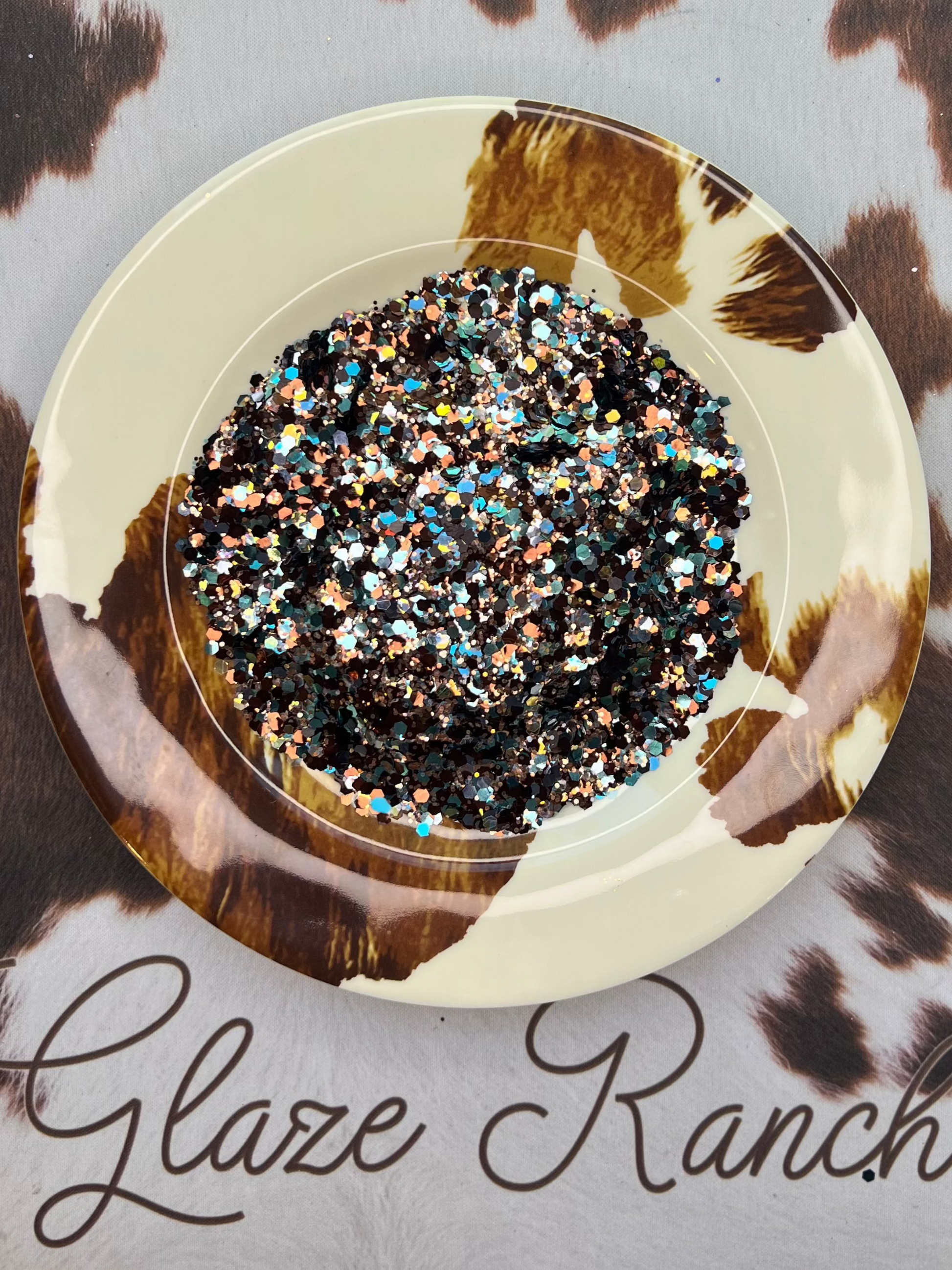 Decorative bowl with decorative stones on a cowhide surface with 'Glaze Ranch' branding.