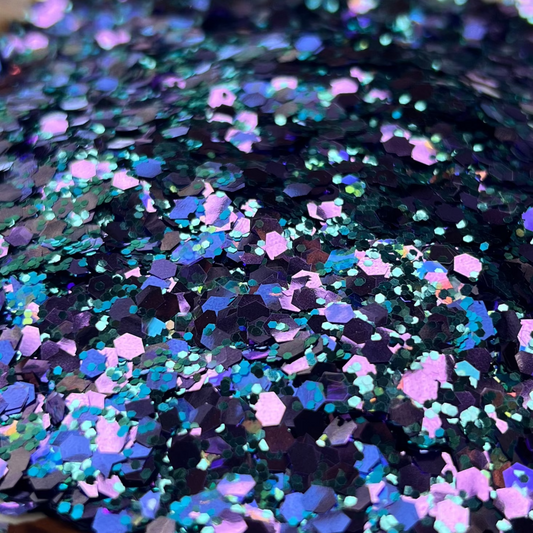 Multicolored glitter on a white plate with brown floral patterns