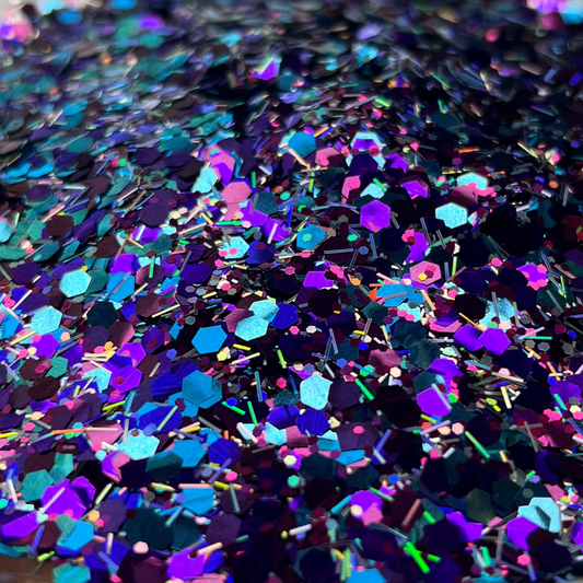 Multicolored glitter on a white plate with a brown patterned surface underneath