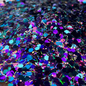 Multicolored glitter on a white plate with a brown patterned surface underneath