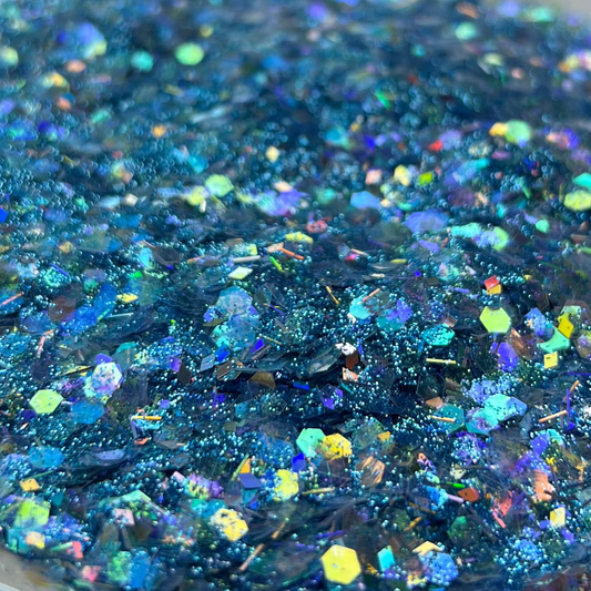 Blue glittery substance on a white plate with a blurred background