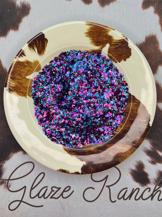 Decorative plate with glittery center on a cowhide-patterned surface, branded 'Glaze Ranch'.