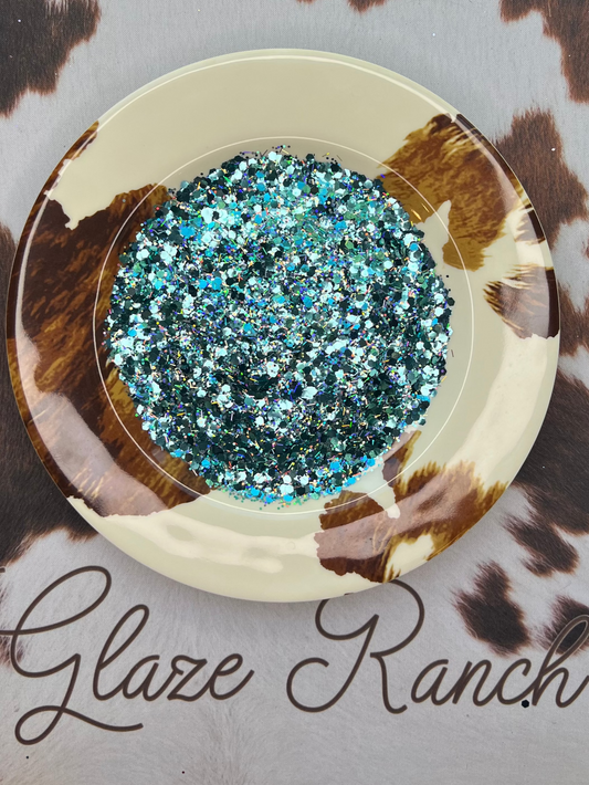 Decorative plate with blue glitter on a cow print background, featuring 'Glaze Ranch' branding.