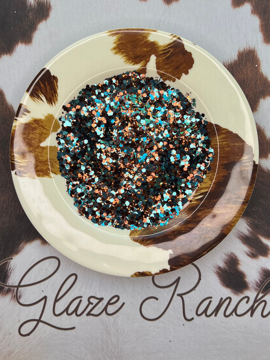 Decorative plate with turquoise and brown glitter on a cowhide surface with 'Glaze Ranch' branding.